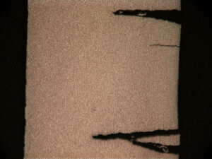 Low magnification photomicrograph of the transverse cross-section across several of the internal secondary cracks. The cracks have widened during rupture.