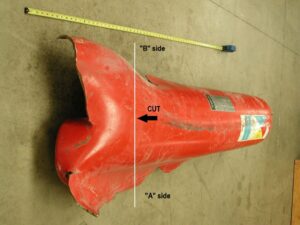 Second view of the as-received ruptured cylinder. The cylinder was sectioned approximately across the dashed line for easier handling and examination.